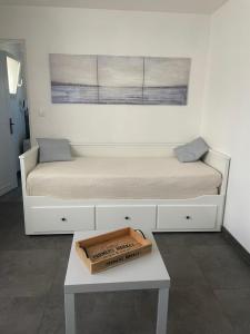 Un dormitorio con una cama y una mesa con una caja. en L'Oseraie, en Moisenay