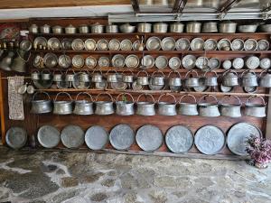 a shelf filled with lots of pots and pans at Hotel Rai in Koprivshtitsa
