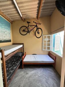 Un dormitorio con una bicicleta colgada en la pared. en Viva a vibe - Caragua, en Caraguatatuba