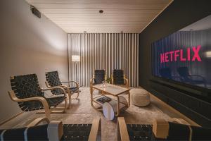 a waiting room with a tv and chairs and a table at Arctic Design Villa Levi in Levi