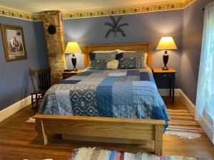 a bedroom with a bed with a blue comforter at Rainbow Ridge Farms in Onalaska