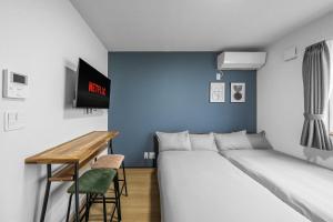 a bedroom with two beds and a desk and a tv at Charmant House III - Vacation STAY 20371 in Minamifurano