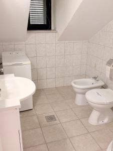 a white bathroom with a toilet and a sink at Humac Vero Apartments in Donji Humac