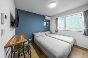 a bed in a room with a blue wall at Charmant House III - Vacation STAY 20371 in Minamifurano