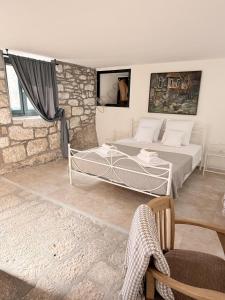 a bedroom with a bed and a stone wall at Humac Vero Apartments in Donji Humac