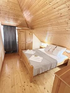 a bedroom with a large bed with a wooden ceiling at Humac Vero Apartments in Donji Humac +40 photos