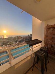 ein Klavier auf einem Balkon mit einem Pool in der Unterkunft Moderno Departamento 1 h 1 b, Excelente Ubicación in Iquique