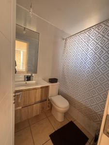 ein Badezimmer mit Toilette, Waschbecken und Spiegel in der Unterkunft Moderno Departamento 1 h 1 b, Excelente Ubicación in Iquique