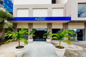 a building with palm trees in front of it at El Aram Beach Express in Maceió