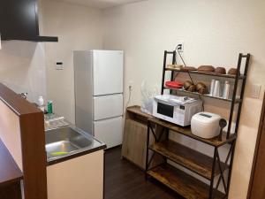 a small kitchen with a sink and a refrigerator at ASUBIYADO - Vacation STAY 59256v in Ushuku +5 photos