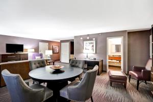 una sala de estar con una mesa y sillas en DoubleTree by Hilton Downtown Wilmington - Legal District, en Wilmington