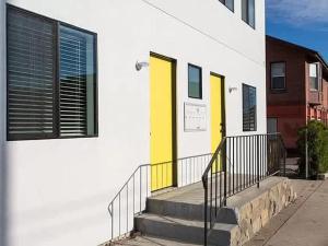 a building with yellow doors and stairs on a street at Sunny Studio in the Heart of Venice - A in Los Angeles
