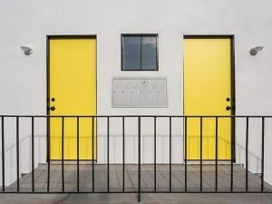two yellow doors on the side of a building at Sunny Studio in the Heart of Venice - A in Los Angeles