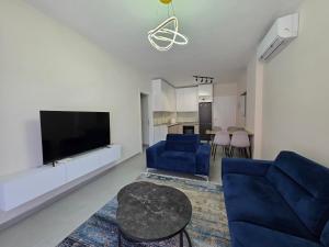 a living room with a blue couch and a tv at Mira Apartment in Tirana +10 photos