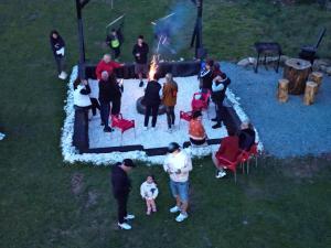 a group of people standing around a fire pit at CASA BINU in Arieşeni