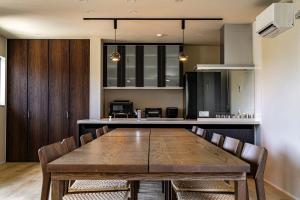 une salle à manger avec une table et une cuisine dans l'établissement SANA Izu Omuroyama -Pool Villa- - Vacation STAY 61808v, à Futo