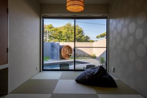 Cette chambre dispose d'une grande fenêtre donnant sur une piscine. dans l'établissement SANA Izu Omuroyama -Pool Villa- - Vacation STAY 61808v, à Futo
