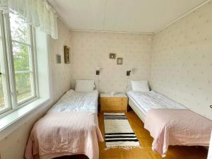 two beds in a room with two windows at 4 star holiday home in KÖPINGSVIK in Köpingsvik