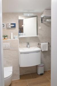 a bathroom with a white sink and a toilet at AdisiTi S1 in Zagreb +10 photos