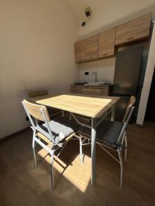 - une cuisine avec une table et des chaises en bois dans la chambre dans l'établissement Loft Emilia, à Castel Bolognese 1 autre photo