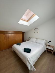 a bedroom with a large white bed with a skylight at Loft Emilia a Castel Bolognese in Castel Bolognese