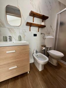 une salle de bain avec un lavabo, des toilettes et un miroir dans l'établissement Loft Emilia, à Castel Bolognese