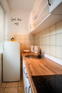 a kitchen with a white refrigerator and a sink at Apartman Gnječ Kupres in Kupres +16 photos