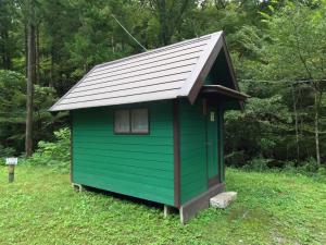 a green shed with a metal roof in a field at Nikko Manaka Forest Camp & Resort - Vacation STAY 65320v in Nikko