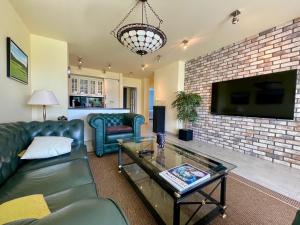 a living room with a couch and a tv at Apartament przy polu golfowym in Niesulice