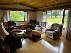 a living room with three chairs and a coffee table at Cozy Farmhouse B&B Retreat in Williams Lake