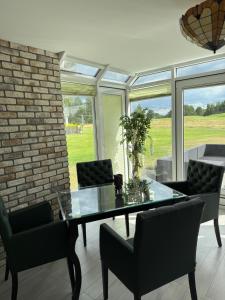 a dining room with a glass table and chairs at Apartament przy polu golfowym in Niesulice