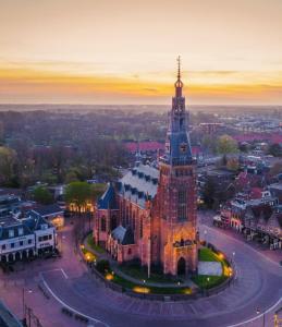 a large building with a clock tower in a city at B&B Ztrand in Oudesluis