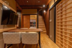 ein Esszimmer mit einem Holztisch und Stühlen in der Unterkunft [Kyoran Touen Residence] - Vacation STAY 65169v in Kyōto + 41 Fotos