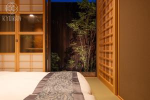 ein Schlafzimmer mit einem Bett und ein Fenster mit einer Pflanze in der Unterkunft [Kyoran Touen Residence] - Vacation STAY 65169v in Kyōto