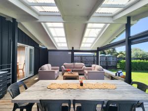 a large patio with a table and chairs at Seashell Cottage Hahei in Hahei +15 photos