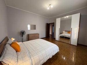 Un dormitorio con una cama grande y un espejo. en Casa Ortensia Saronno, en Saronno