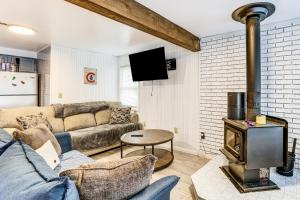 a living room with a couch and a wood stove at Lake Access! All-Season Fun at Reed City Home in Reed City