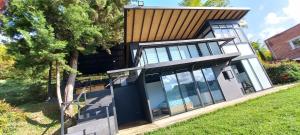 a house with glass doors and a tree at Villa Lake Blue in El Peñol