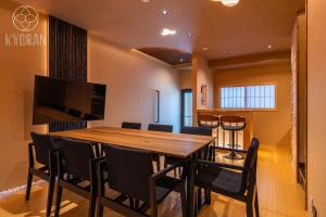 ein Esszimmer mit einem Holztisch und Stühlen in der Unterkunft Kyoran Yuzen - Vacation STAY 65318v in Kyōto