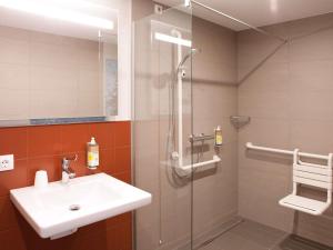 a bathroom with a sink and a glass shower at greet Wien City Nord in Vienna