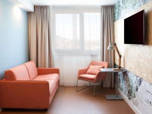 a living room with a couch and two chairs at greet Wien City Nord in Vienna