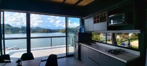 a kitchen with a large window with a view of the water at Villa Lake Blue in El Peñol