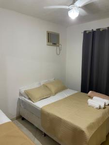 une chambre avec un lit et une télévision au mur dans l'établissement Loft da Praia dos Corais, à Cabo Frio