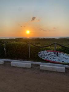 un bateau posé sur une clôture avec le coucher de soleil en arrière-plan dans l'établissement Loft da Praia dos Corais, à Cabo Frio 12 autres photos