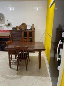 - une table et des chaises en bois dans la cuisine dans l'établissement Loft da Praia dos Corais, à Cabo Frio