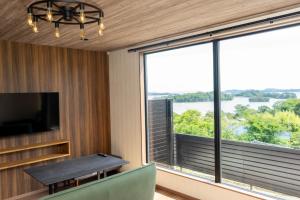a room with a table and a large window at Tabinoteitaku BREATHTAKEMatsushima - Vacation STAY 66188v in Takagi
