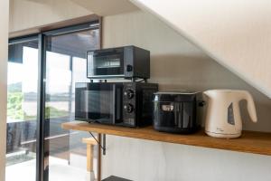 a microwave sitting on a shelf next to a coffee maker at Tabinoteitaku BREATHTAKEMatsushima - Vacation STAY 66188v in Takagi +13 photos