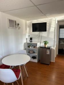 a living room with a white table and a tv at Depto Independiente Mostazal in La Punta