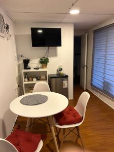 a room with a table and chairs and a tv at Depto Independiente Mostazal in La Punta