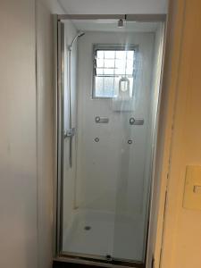 a shower with a glass door in a bathroom at Depto Independiente Mostazal in La Punta